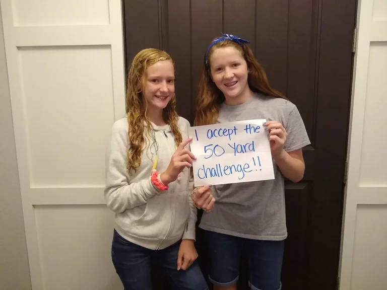 Two girls holding a challenge sign